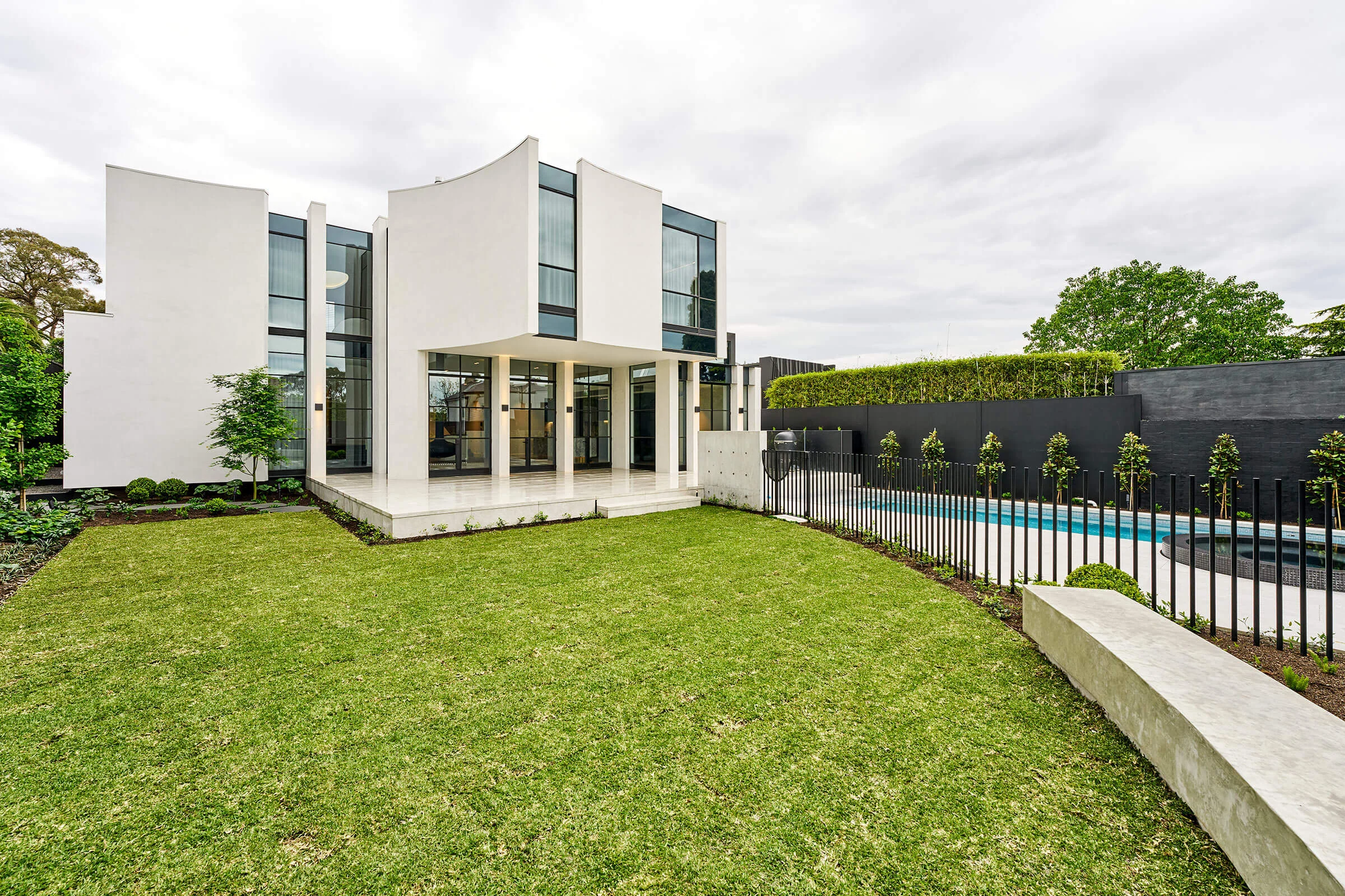 Hawthorn Project by JD, sculpted white exterior with tall glazing opening onto the garden