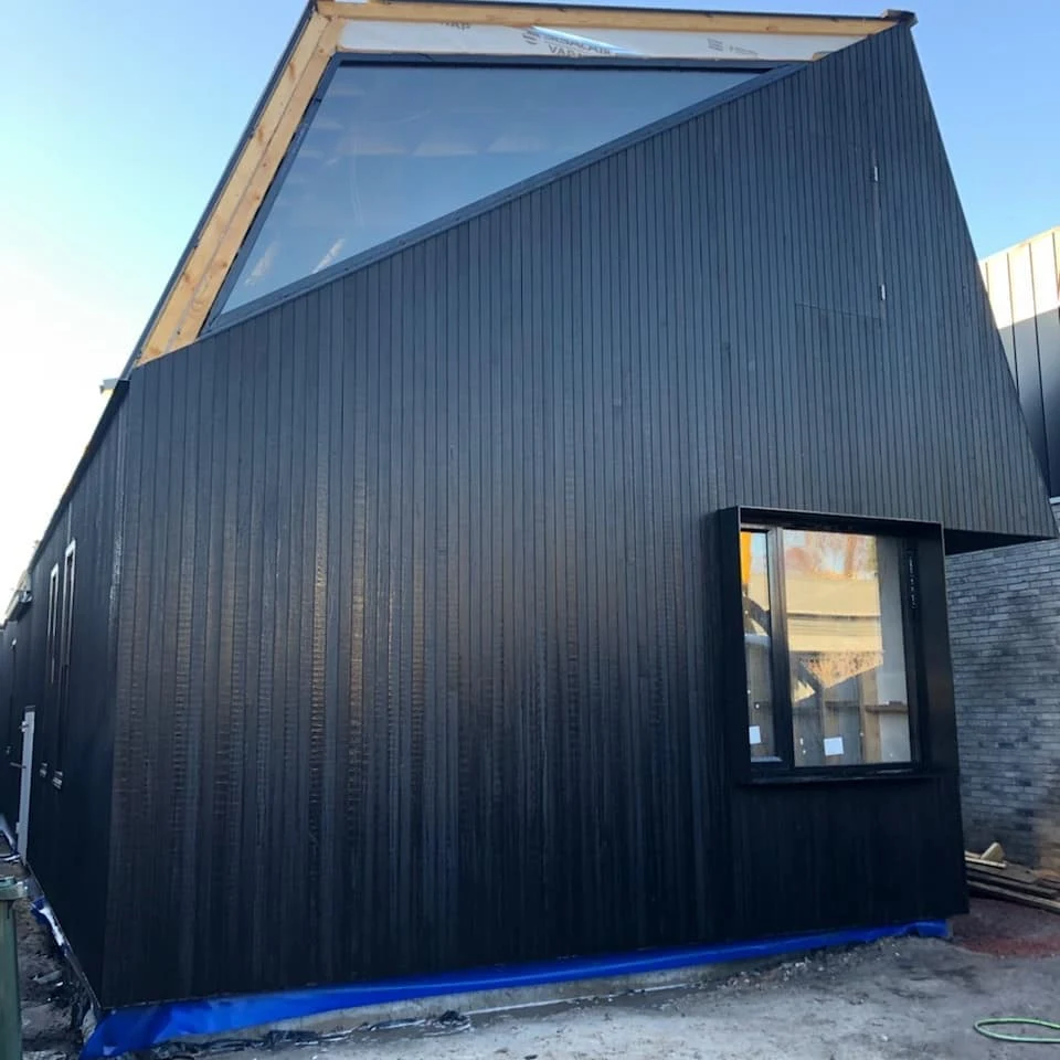 Windsor, dark vertical cladding and angular roof during construction